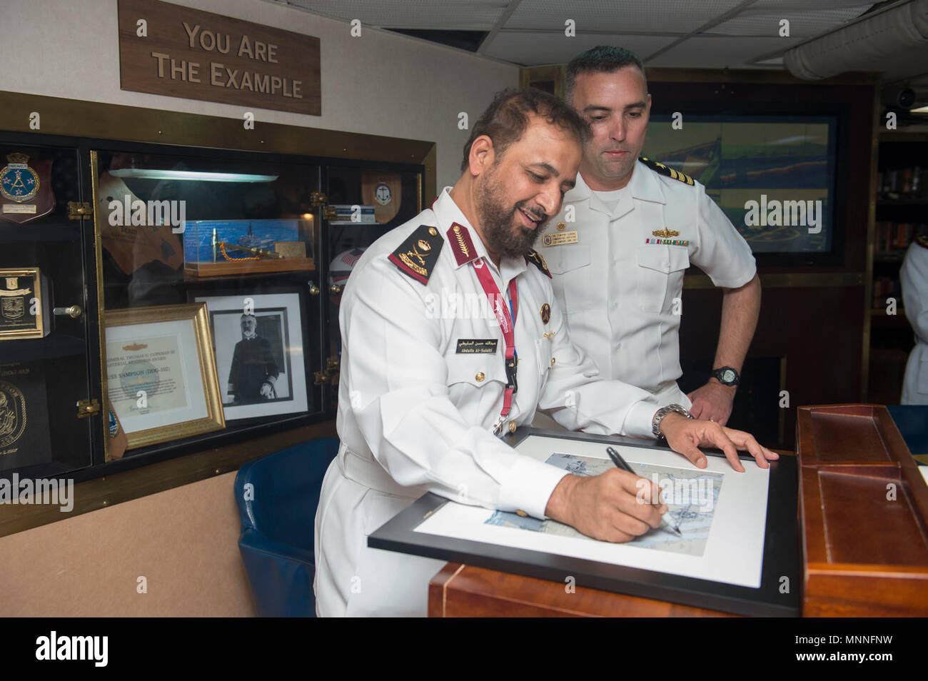 DOHA, Qatar (March 11, 2018) Maj. Gen. Abdulla bin Hassan Al Sulaiti, commander of the Qatar Emiri Naval Forces signs a portrait during his visit aboard the Arleigh Burke-class guided-missile destroyer USS Sampson (DDG 102). Sampson is deployed with the Theodore Roosevelt Carrier Strike Group to the U.S. 5th Fleet area of operations in support of maritime operations to reassure allies and partners and preserve the freedom of navigation and the free flow of commerce in the region. Stock Photo