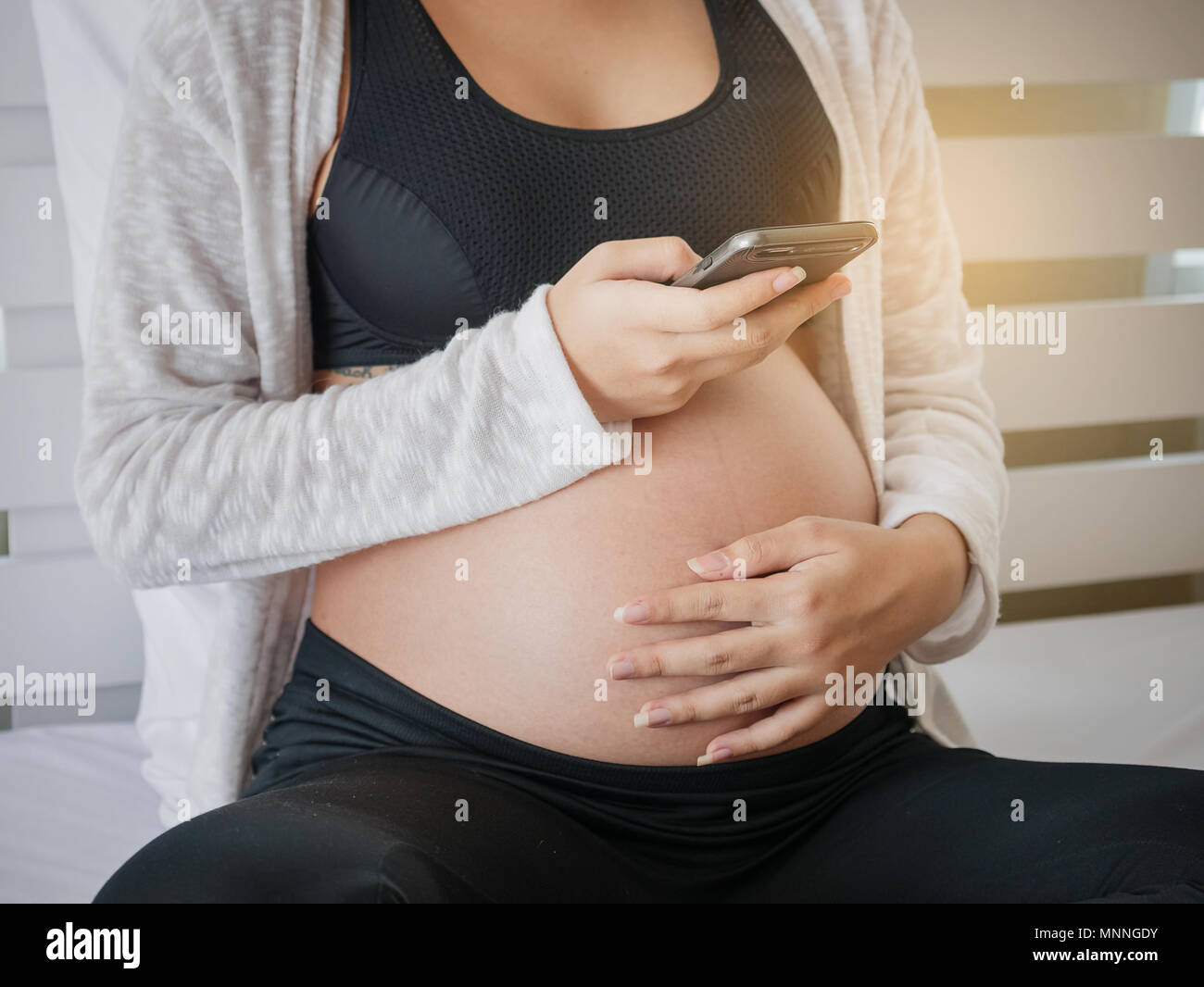 Pregnant woman use mobile smart phone while sitting in bed and relaxing, Pregnancy and technology Stock Photo - Alamy