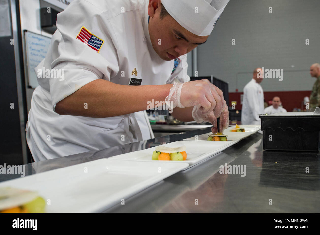 Fort Lee, Va. (March 14, 2018) Sgt. Klinton Bautista, representing Joint Base Lewis McChord, Washington, plates a meal during the nutrition competition as part of the Joint Culinary Training Exercise (JCTE). The annual Fort Lee JCTE is the largest American Culinary Federation-sanctioned competition in North America. Stock Photo