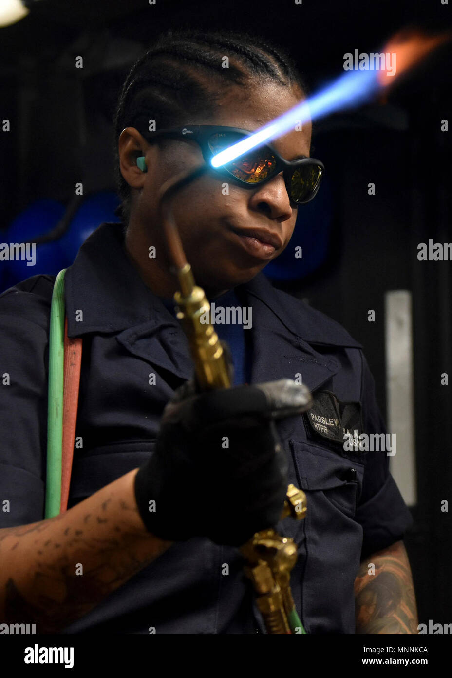 YOKOSUKA, Japan (March 16, 2018) -  Hull Maintenance Technician Fireman Cola Parsley, from New York City, attached to the USS Blue Ridge (LCC 19), makes pipe repairs by silver brazing. Silver brazing is the process of joining two pieces of metal using thin film of silver brazing filler metal. Blue Ridge and her crew have now entered a final upkeep and training phase in preparation to become fully mission capable for operations. Stock Photo