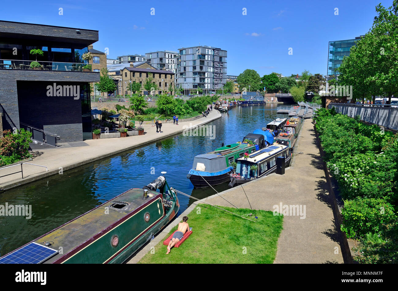 Barges and people on Regents Canal, behind Kings Cross Station, London, England, UK Stock Photo