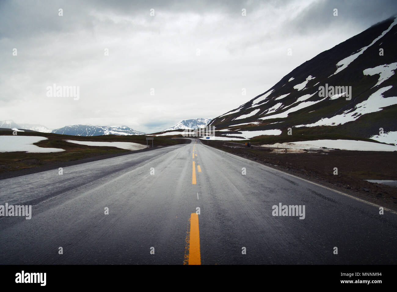 Scenic view on the E6 in Norway with snow covered mountains on a cloudy overcast day in the summer. Stock Photo