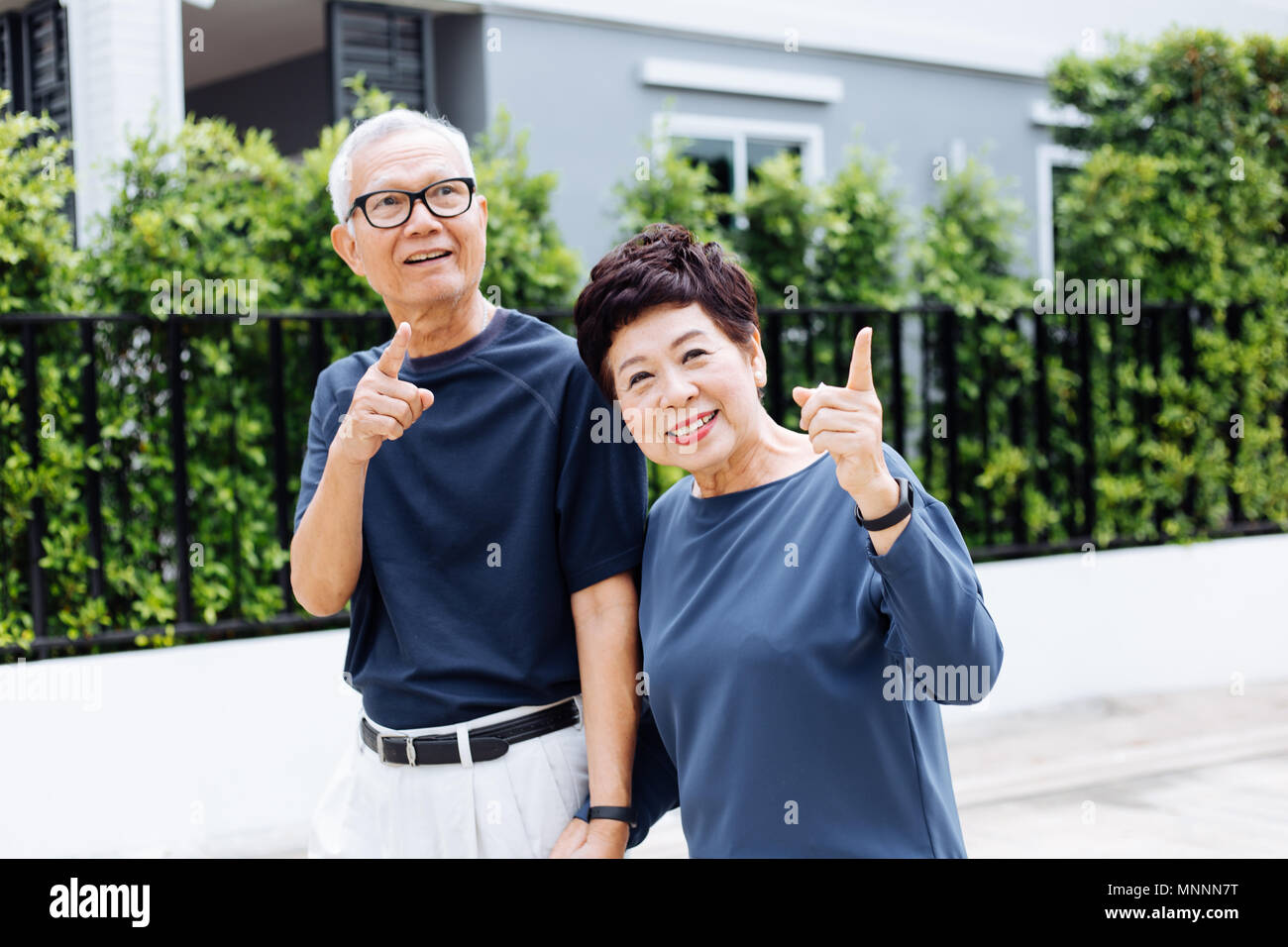 Happy senior Asian couple walking and pointing in outdoor park and ...