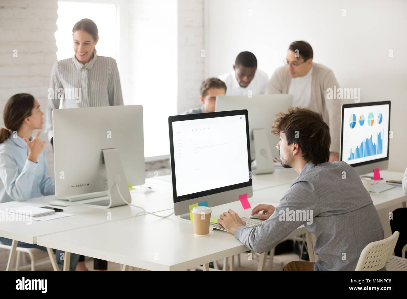 Diverse corporate employees group working together using compute Stock Photo