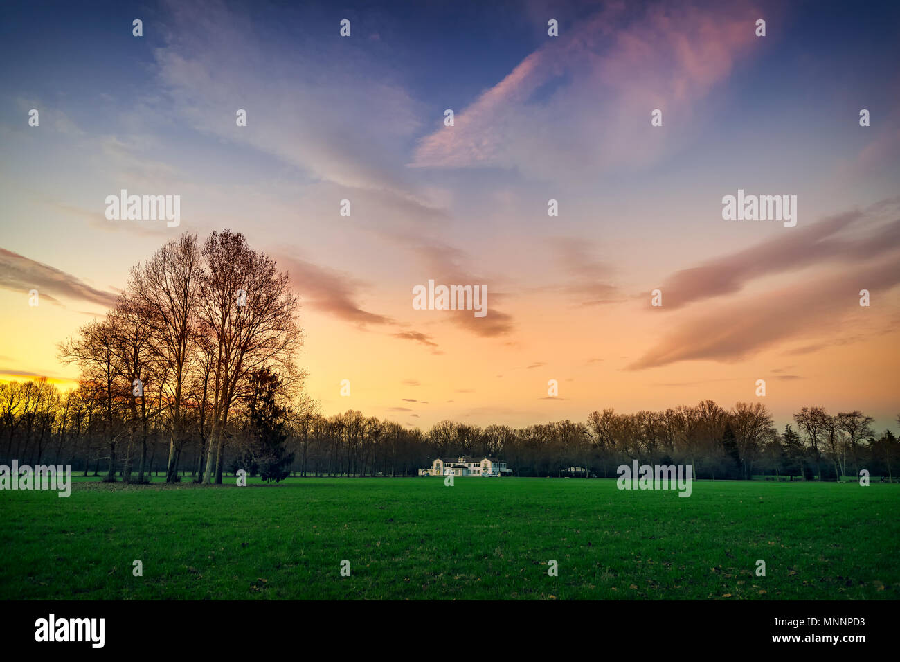 A white farmhouse in the park of Monza surrounded by green meadows at