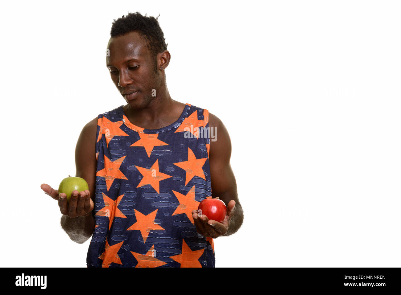 Young black African man choosing between green and red apple Stock ...