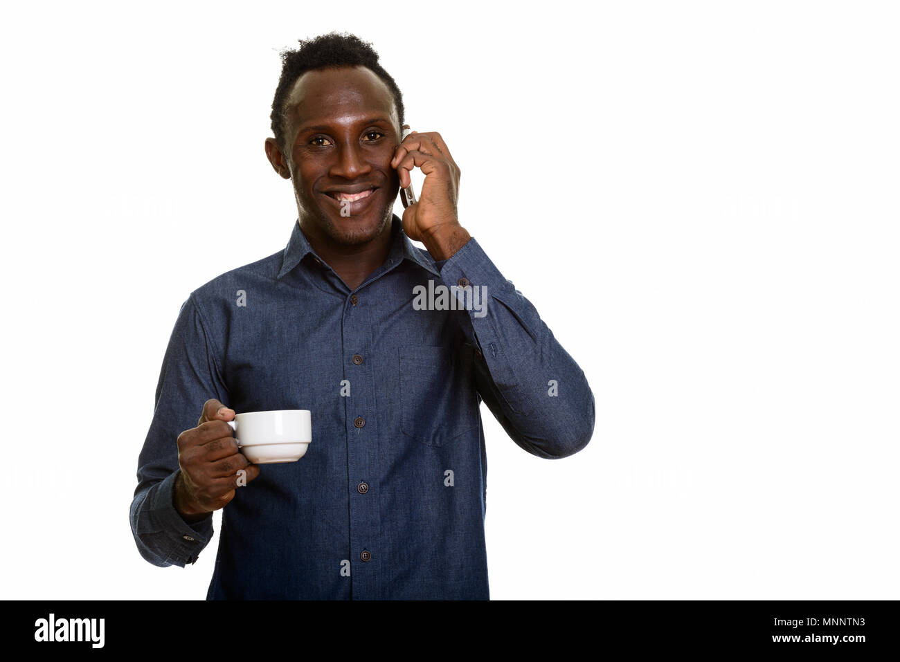 Young happy African man smiling while  talking on mobile phone a Stock Photo