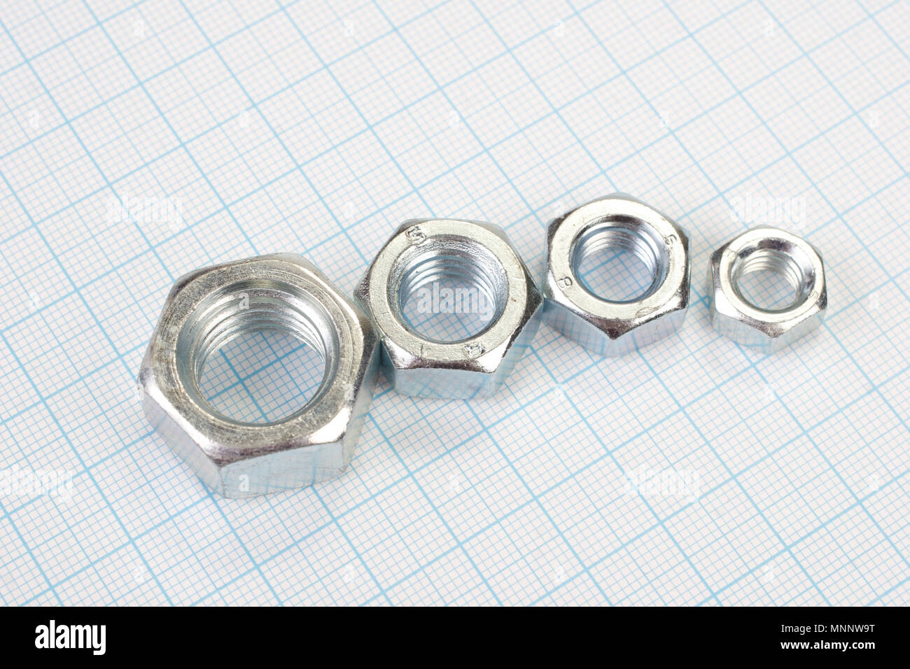 Nuts on graph paper background Stock Photo - Alamy