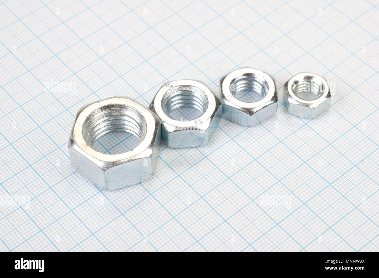 Nuts on graph paper background Stock Photo - Alamy