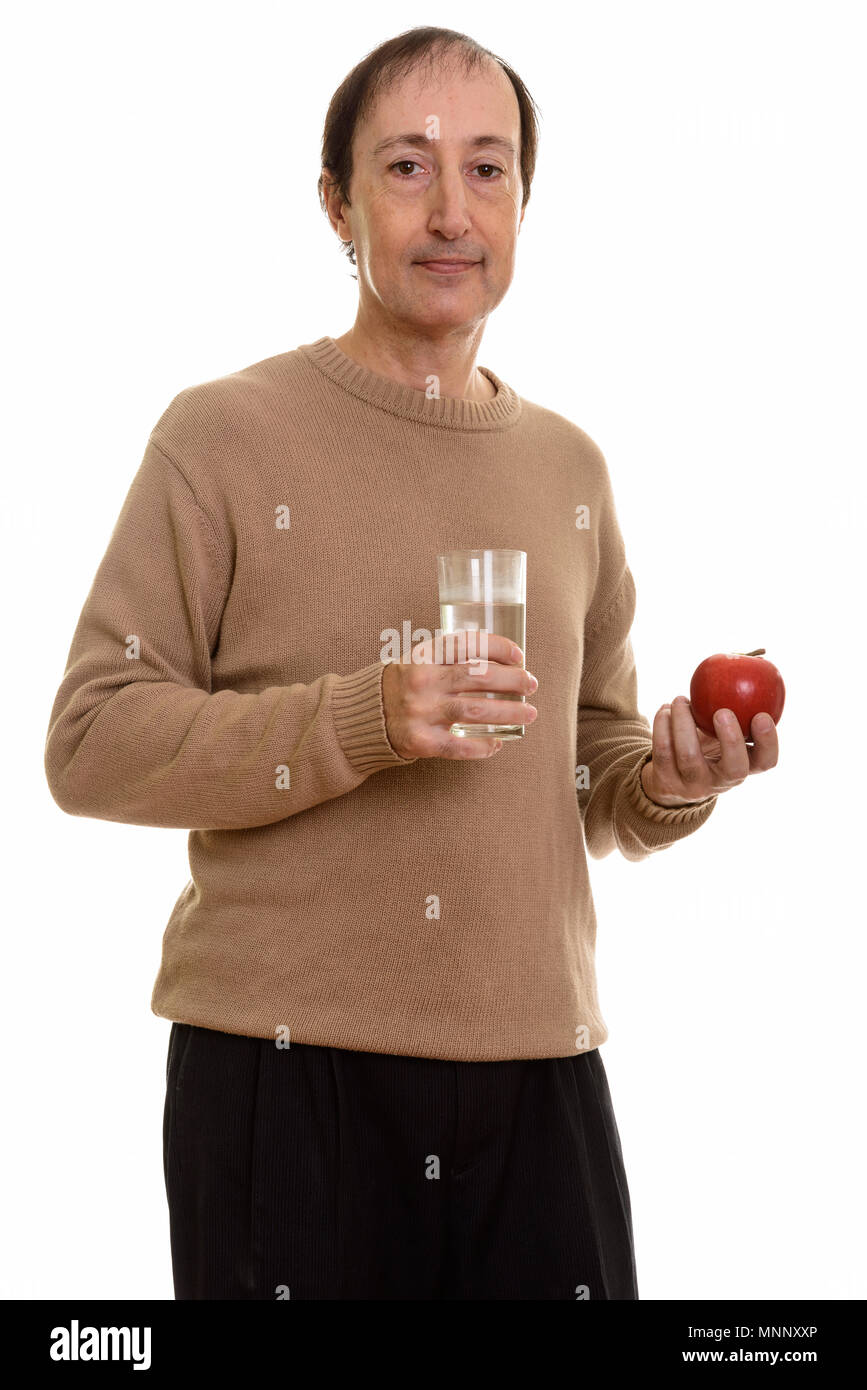 Studio shot of mature man holding glass of water and red apple Stock Photo