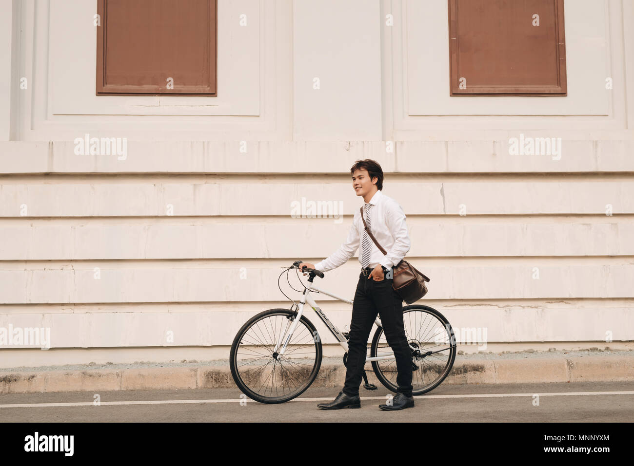 Outdoor portrait of handsome young man with fixed gear bicycle in the street. Stock Photo