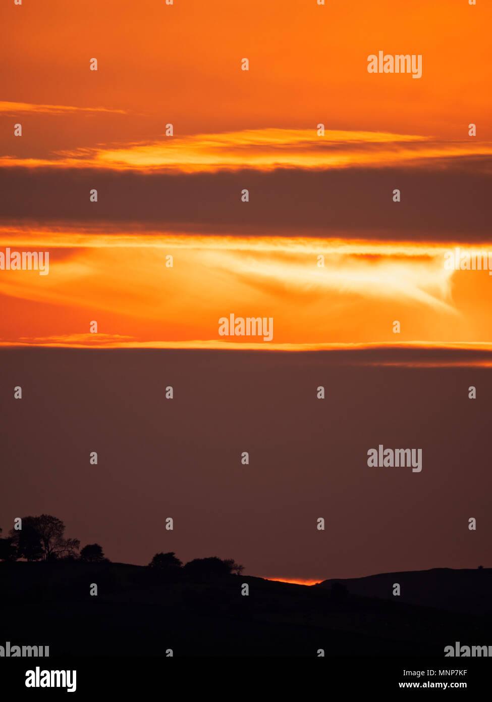 Peak District, Derbyshire, UK. 18th May, 2018. UK Weather: spectacular sunset over the ancient woods Hazleton Clump Cairn near Thorpe taken from Ashbourne Derbyshire, Peak District National Park Credit: Doug Blane/Alamy Live News Stock Photo