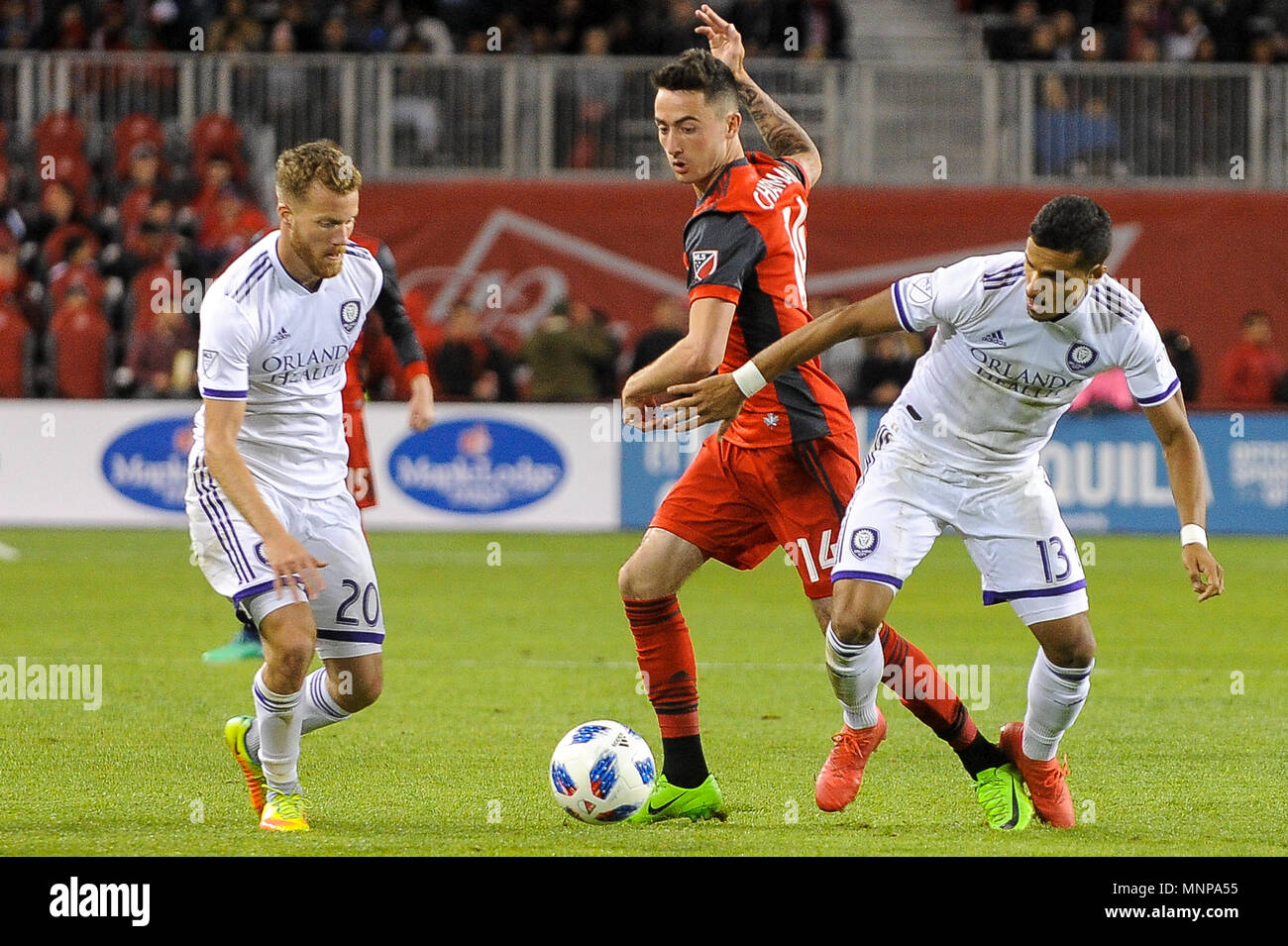 Jay Chapman (M) between two rivals during 2018 MLS Regular Season match between Toronto FC (Canada) and  Orlando City SC (USA) at BMO Field (Score 2:1) Stock Photo