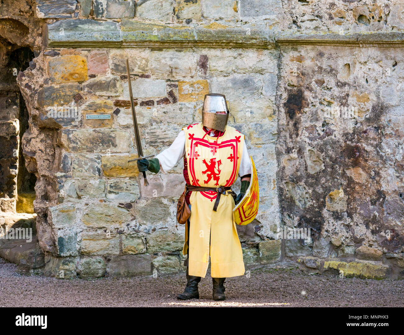 Dirleton, East Lothian, Scotland, UK, 19th May 2018.  Dirleton, East Lothian, Scotland, UK, 19th May 2018.  Dirleton Castle attack re-enactment. The Historic Saltire Society staging a tongue-in-cheek re-enactment of an attack by Robert the Bruce, King of Scotland, around 1311, to take the castle from the English, dressed in authentic clothes and armour and wielding replica weapons in Historic Environment Scotland's Dirleton Castle. A man playing Robert the Bruce dressed in costume with a lion rampant, great helm and sword raised Stock Photo