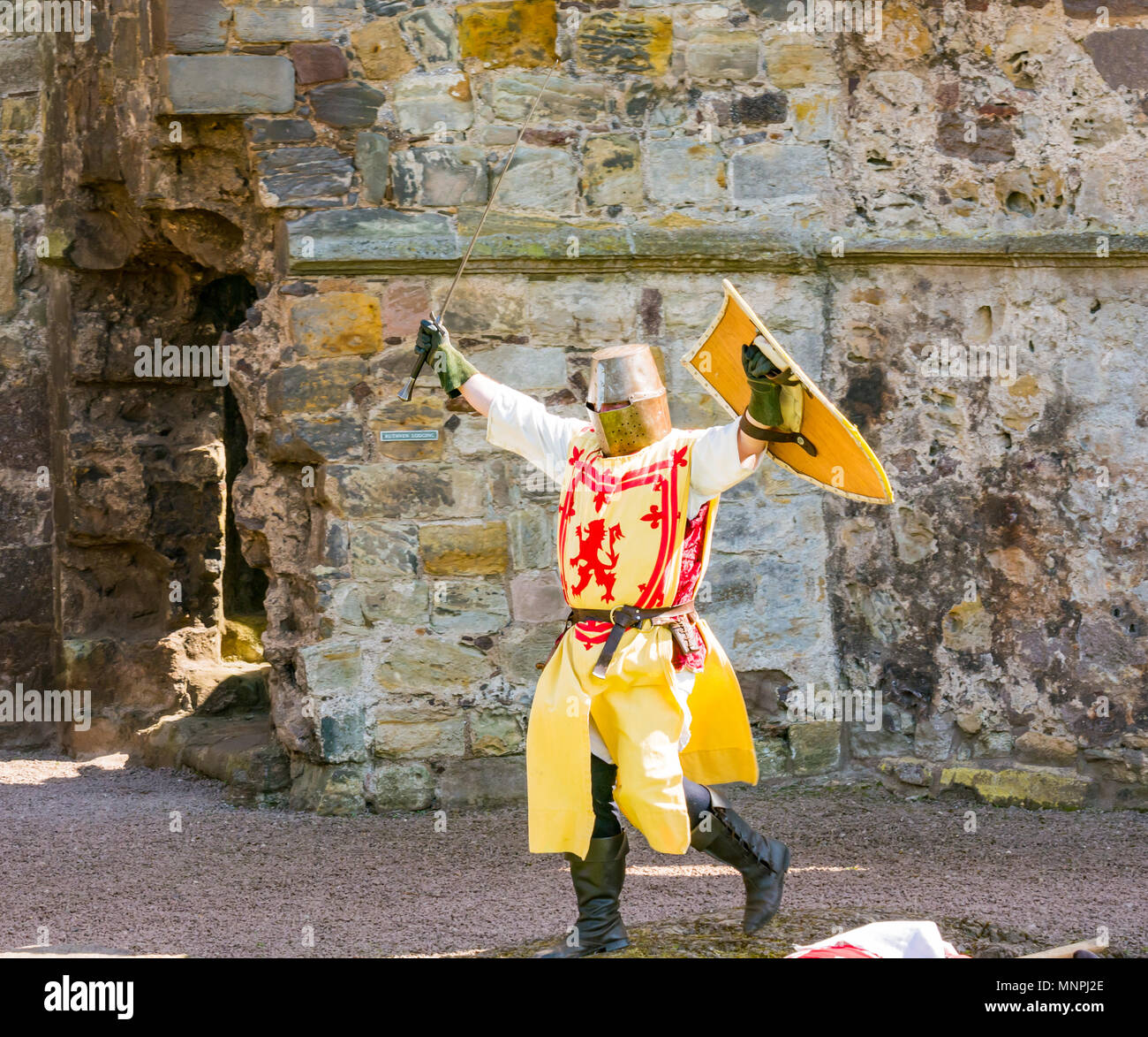 Dirleton, East Lothian, Scotland, UK, 19th May 2018.  Dirleton, East Lothian, Scotland, UK, 19th May 2018.  Dirleton Castle attack re-enactment. The Historic Saltire Society staging a tongue-in-cheek re-enactment of an attack by Robert the Bruce, King of Scotland, around 1311, to take the castle from the English, dressed in authentic clothes and armour and wielding replica weapons in Historic Environment Scotland's Dirleton Castle. A man playing Robert the Bruce dressed in costume with a lion rampant, great helm and sword Stock Photo