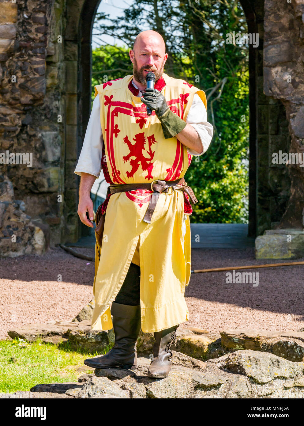 Dirleton, East Lothian, Scotland, UK, 19th May 2018.  Dirleton, East Lothian, Scotland, UK, 19th May 2018.  Dirleton Castle attack re-enactment. The Historic Saltire Society staging a tongue-in-cheek re-enactment of an attack by Robert the Bruce, King of Scotland, around 1311, to take the castle from the English, dressed in authentic clothes and armour and wielding replica weapons in Historic Environment Scotland's Dirleton Castle. A man playing Robert the Bruce dressed in costume with a lion rampant. Stock Photo