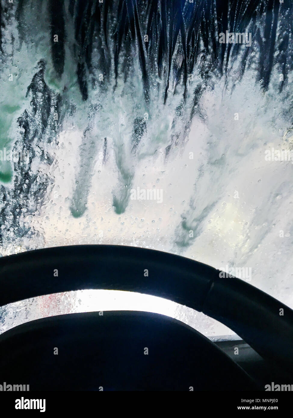 Car steering wheel with wash soap on windshield. Stock Photo