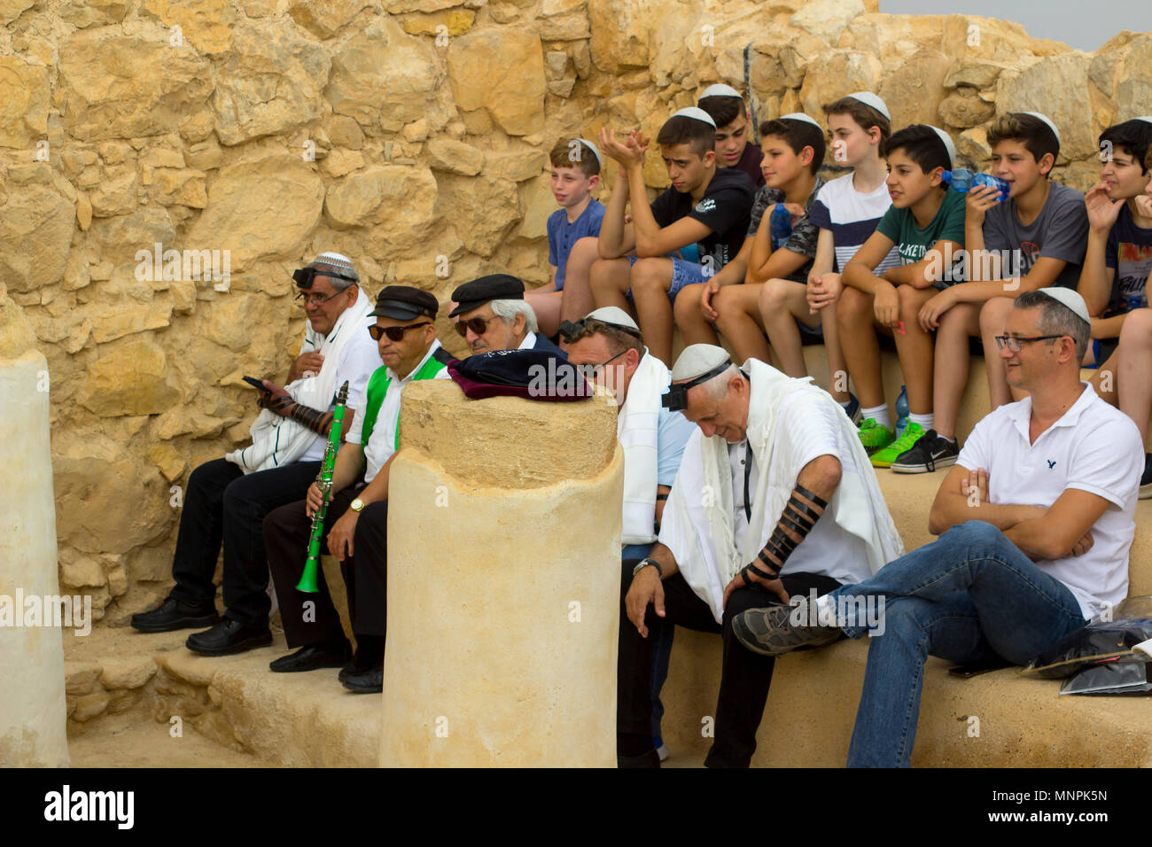 Worshippers taking at an open air Jewish Bar Mitvah  ceremony on the site of the old synagogue at the ancient fortification ruins of Masada in Israel Stock Photo