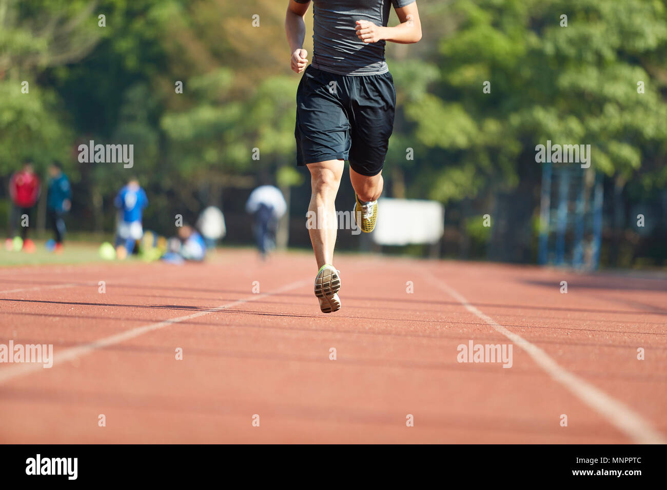 young asian man male athlete running training exercising on track. Stock Photo