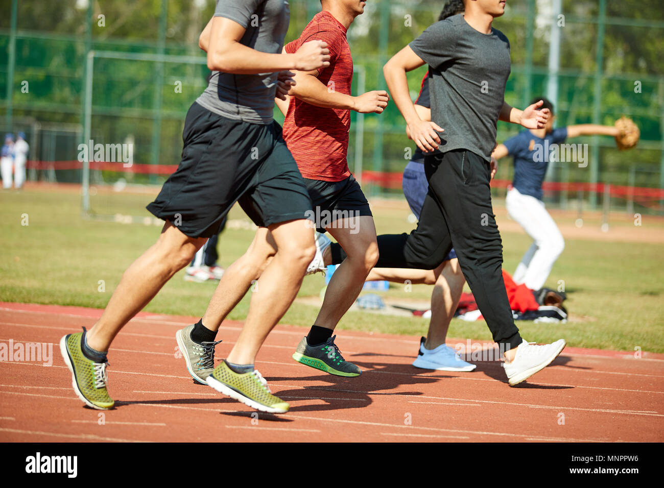 four asian young adults training running on track. Stock Photo