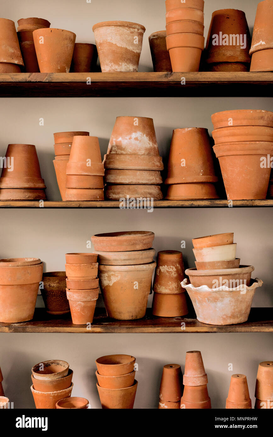 Shelves of stacked vintage earthenware plant pots. Stock Photo