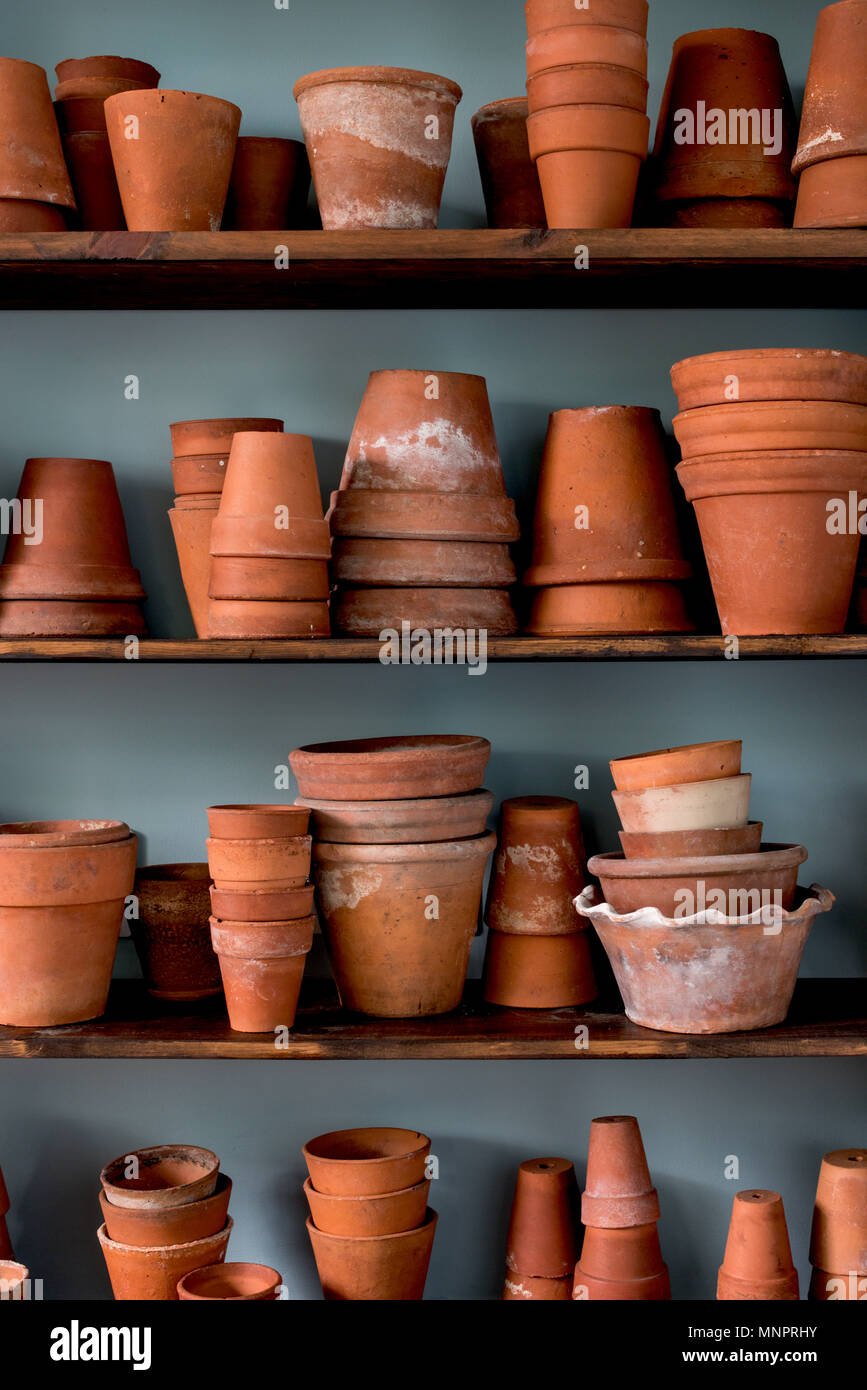 Shelves of stacked vintage earthenware plant pots. Stock Photo