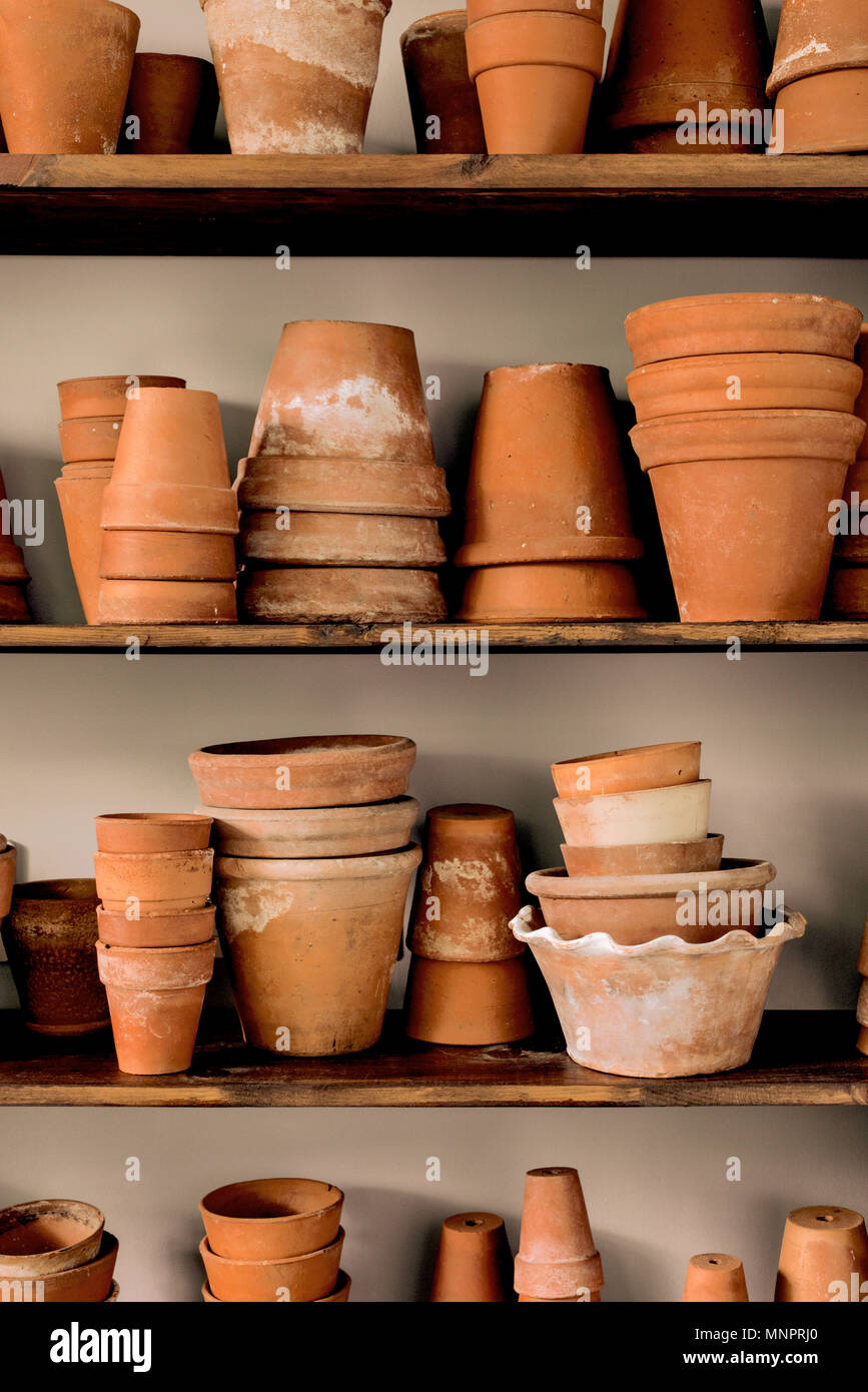 Shelves of stacked vintage earthenware plant pots. Stock Photo
