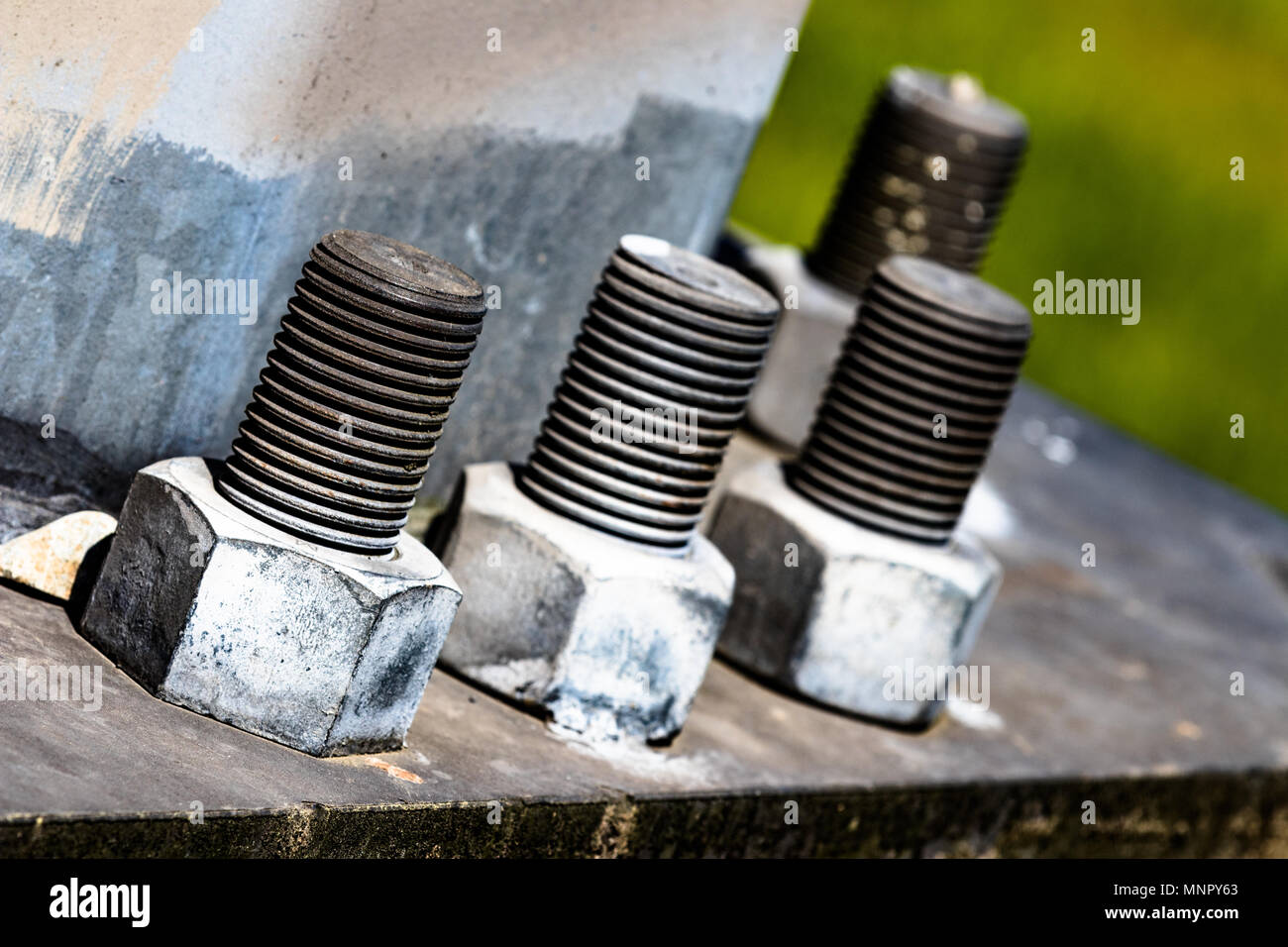 Huge bolts and nuts together in a flange fastening a giant pole in the