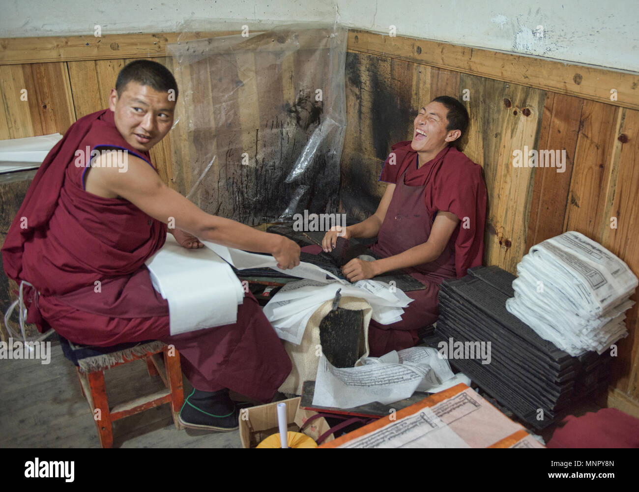 Monks making handmade paper scriptures and woodblock prints inside the holy Bakong Scripture Printing Press Monastery in Dege, Sichuan, China Stock Photo