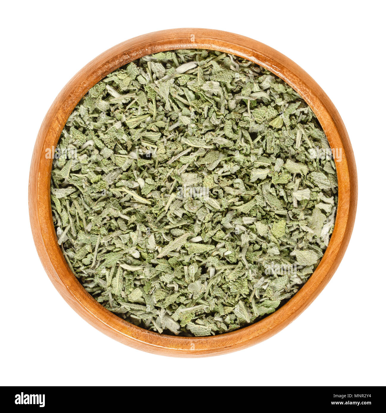 Dried sage in wooden bowl. Also called garden, common or culinary sage. Salvia officinalis. Grayish herb, spice and medical plant. Macro photo. Stock Photo