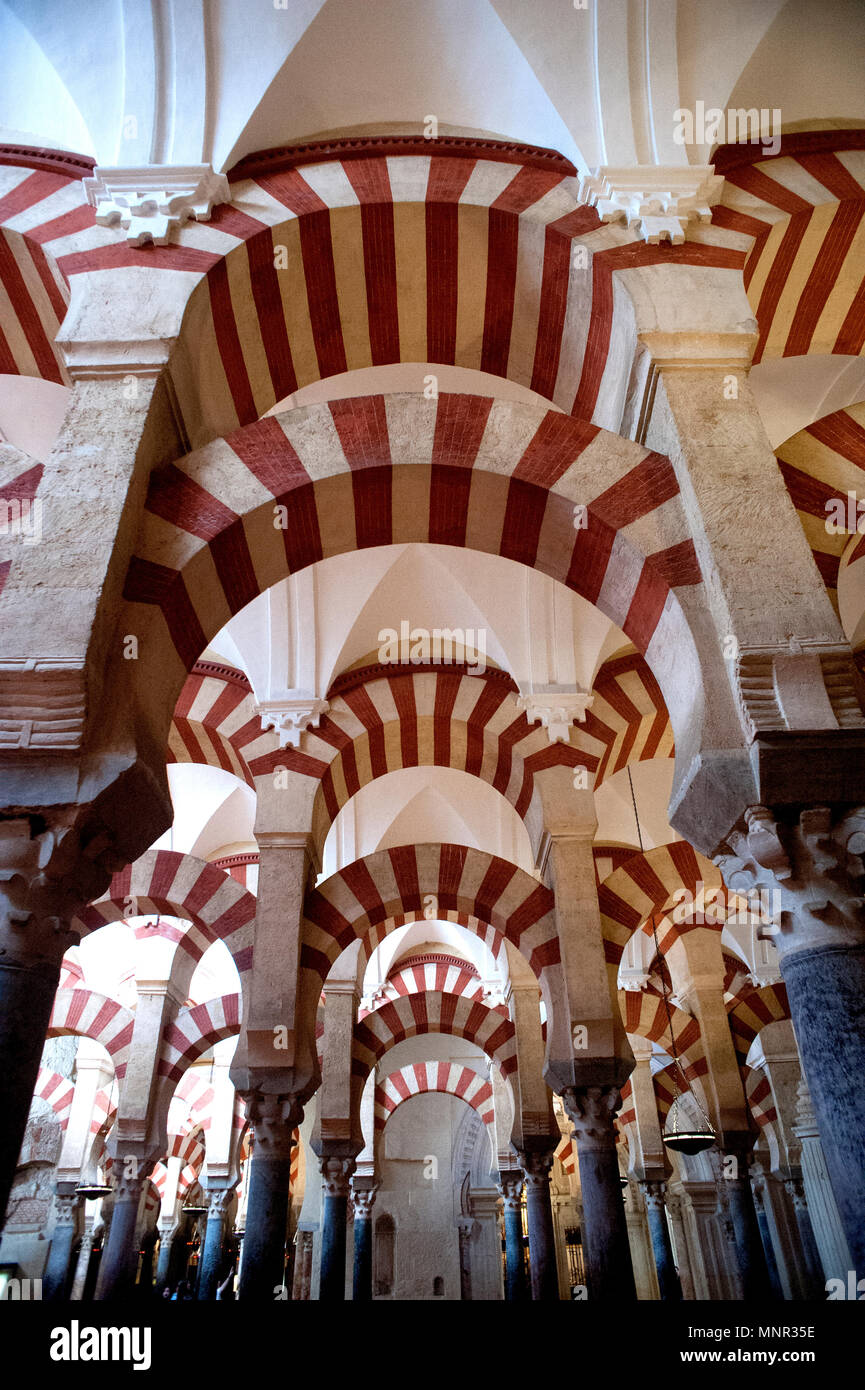 The spectacular architecture of the Mezquita cathedral in Cordoba, Spain with its Moorish architecture and distinctive red and white arches. Stock Photo