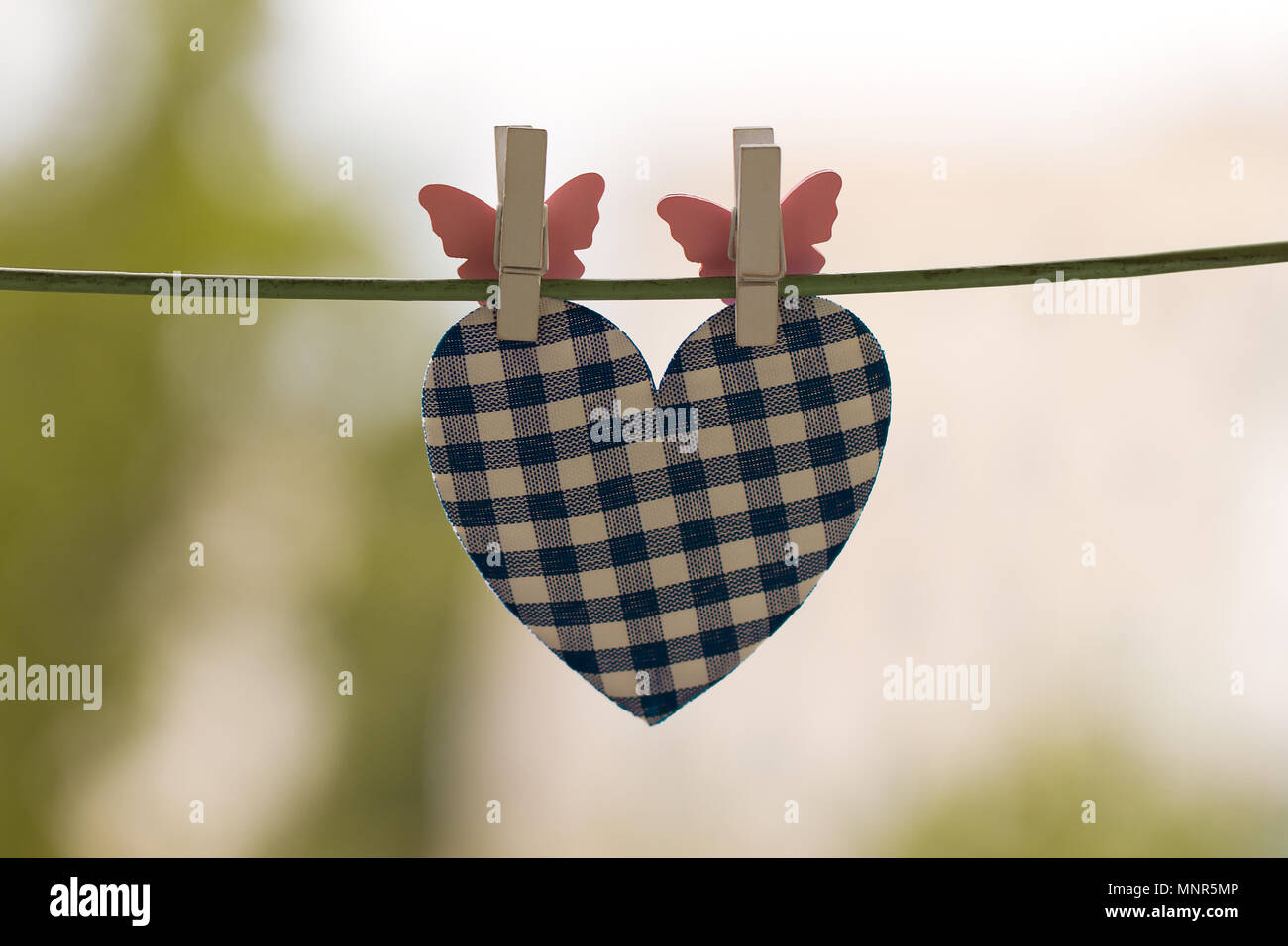 blue heart attached to a clothesline with pin Stock Photo