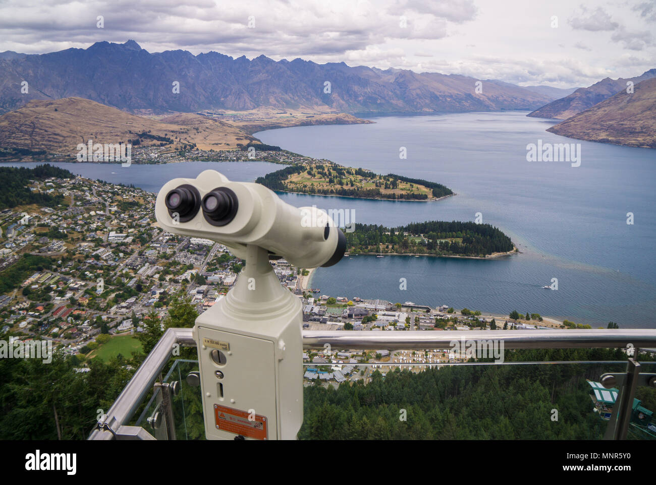 Fixed binoculars at the top of the Skyline Gondola showing the view over Queenstown and Lake Wakatipu in New Zealand Stock Photo