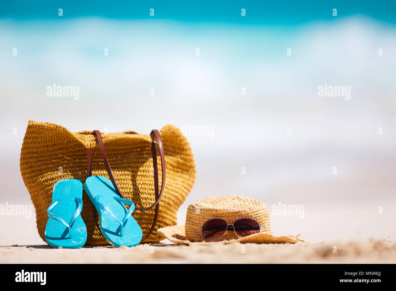 Straw hat, bag, sun glasses and flip flops on a tropical beach Stock ...