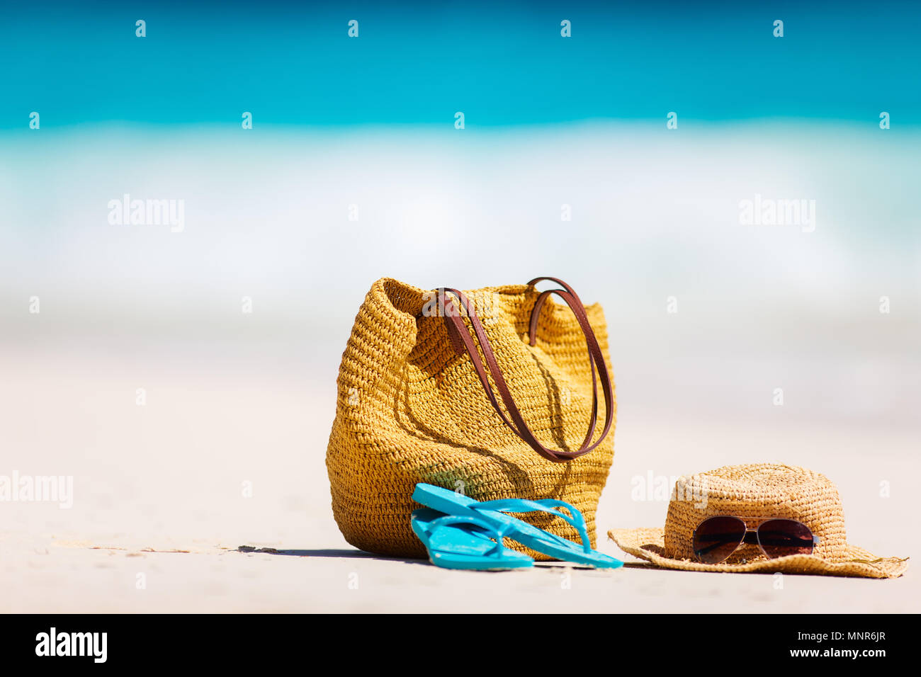Straw bag, sun glasses, towel and flip flops on a tropical beach Stock ...