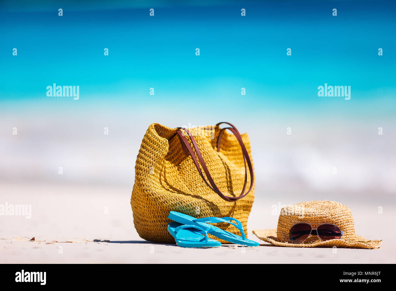 Straw hat, bag, sun glasses and flip flops on a tropical beach Stock ...