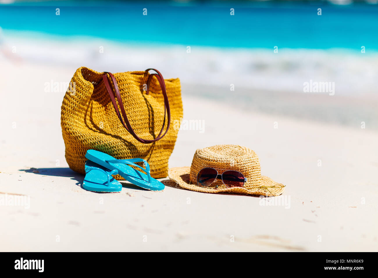 Straw hat, bag, sun glasses and flip flops on a tropical beach Stock ...