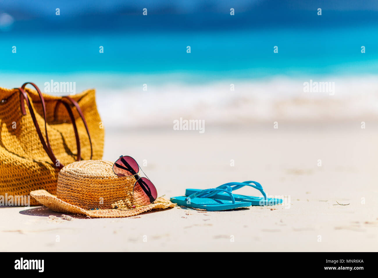 Straw hat, bag, sun glasses and flip flops on a tropical beach Stock ...