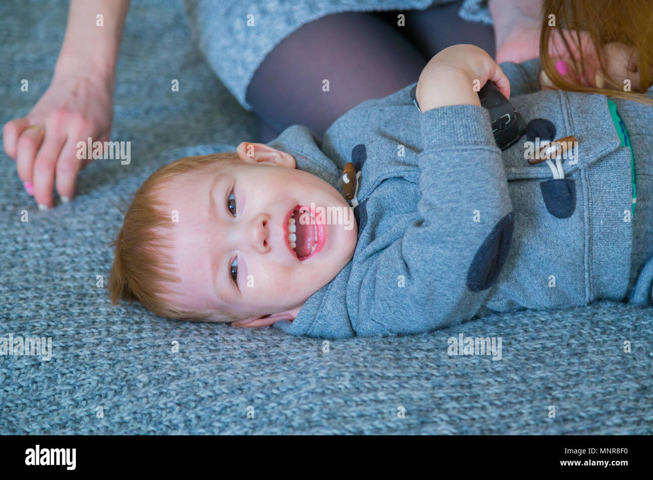 Portrait of happy baby boy. He is lying on the bed Stock Photo