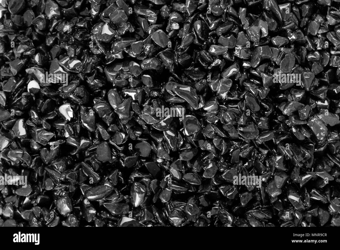 Black small dry pebbles as background. Stock Photo