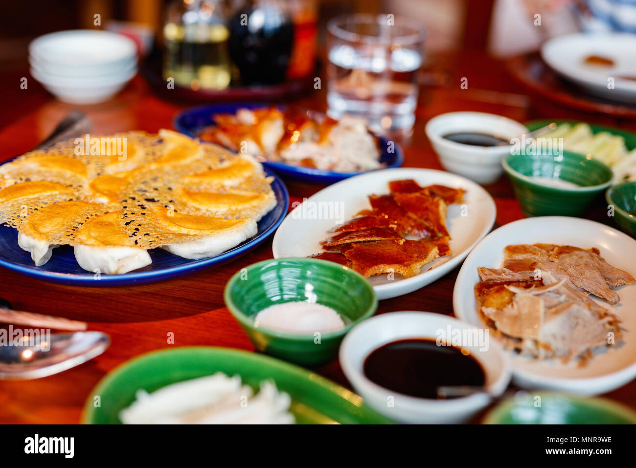 Peking Duck - Chinese roast duck served with pancakes, cucumber, spring onions and plum sauce. Stock Photo