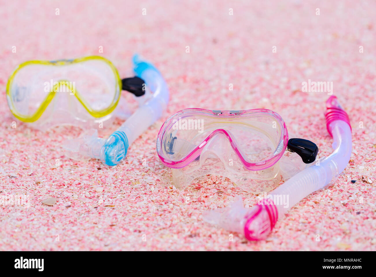 Snorkeling equipment mask and snorkel on beach made of small pink shells Stock Photo