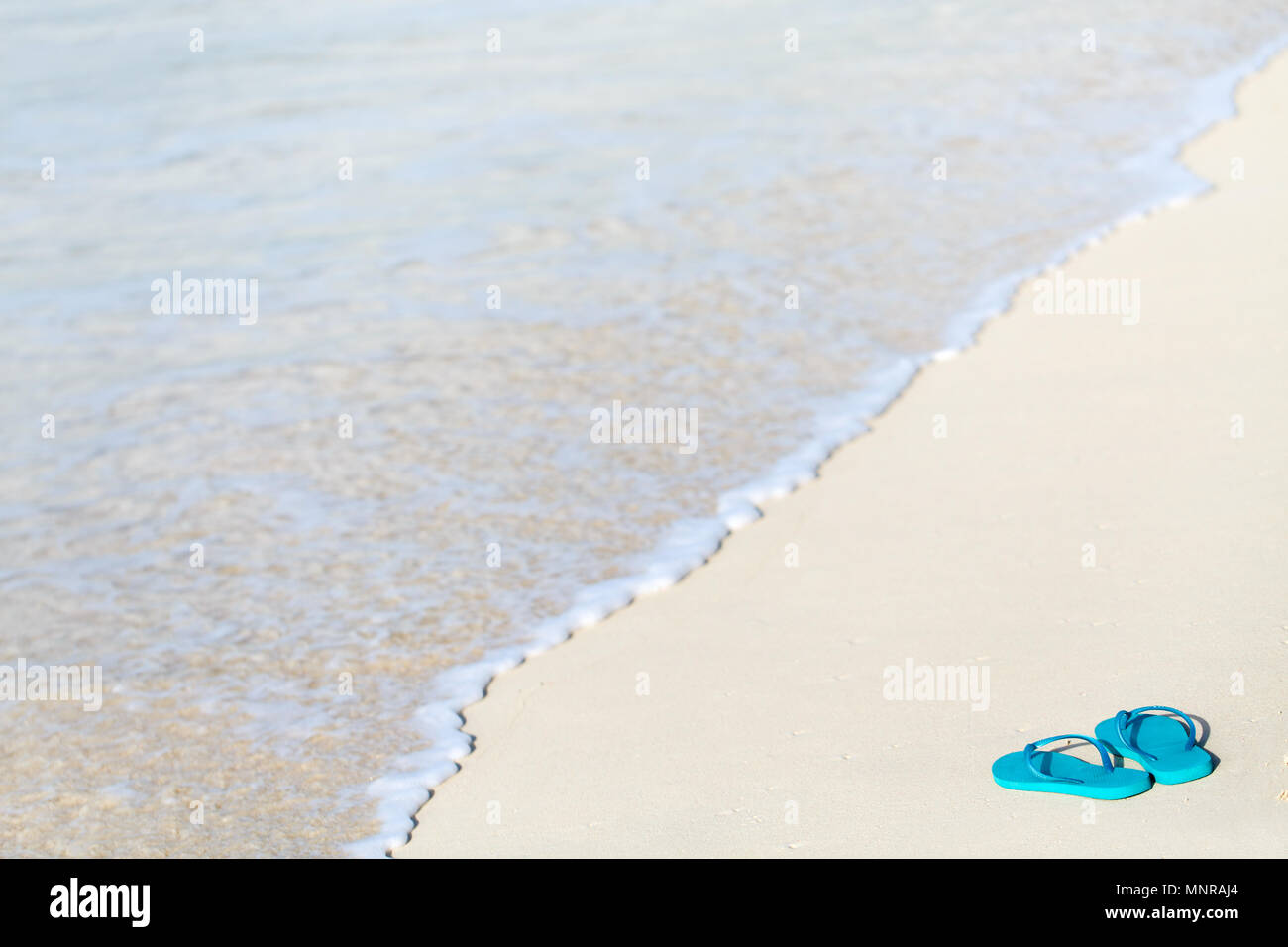 Turquoise flip flops on a tropical beach Stock Photo - Alamy