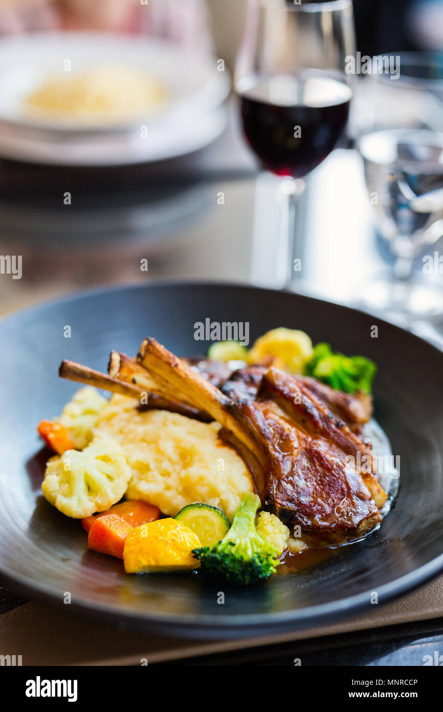 Delicious lunch or dinner with lamb cutlets and red wine in a