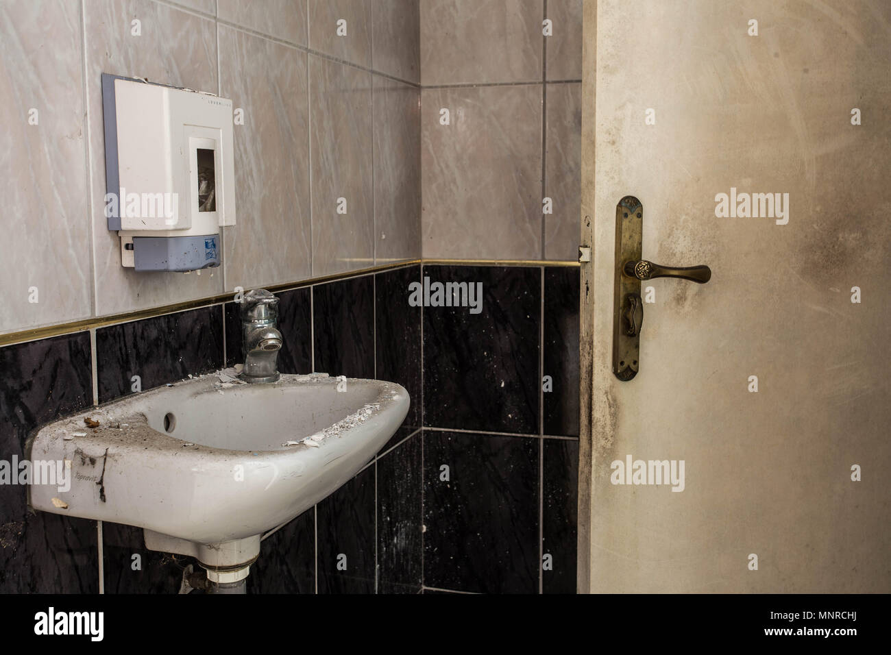 Interior of an old, ruined building, abandoned dirty toilet room Stock Photo