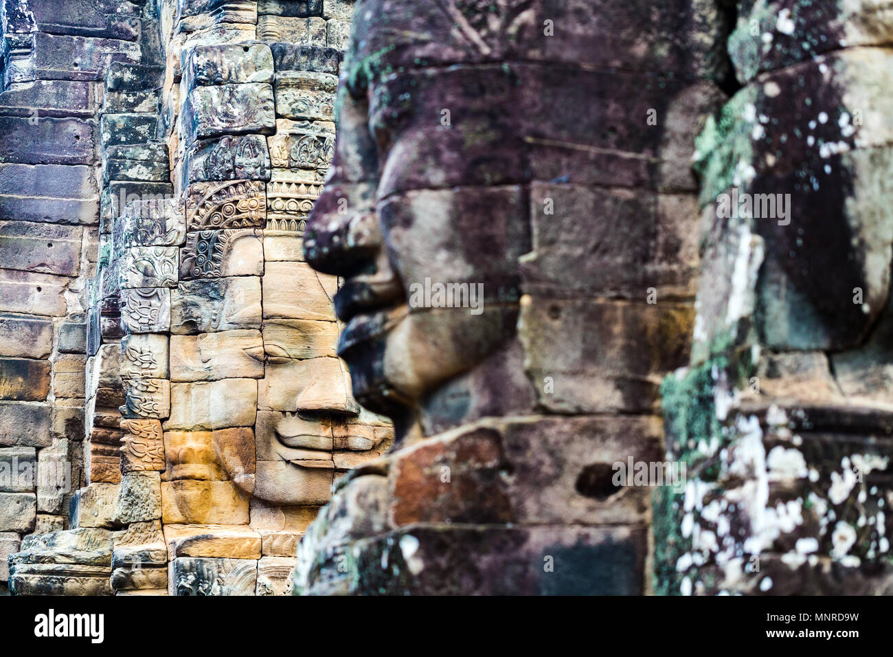 Faces of ancient Bayon temple popular tourist attraction in Angkor Thom,  Siem Reap,  Cambodia. Stock Photo