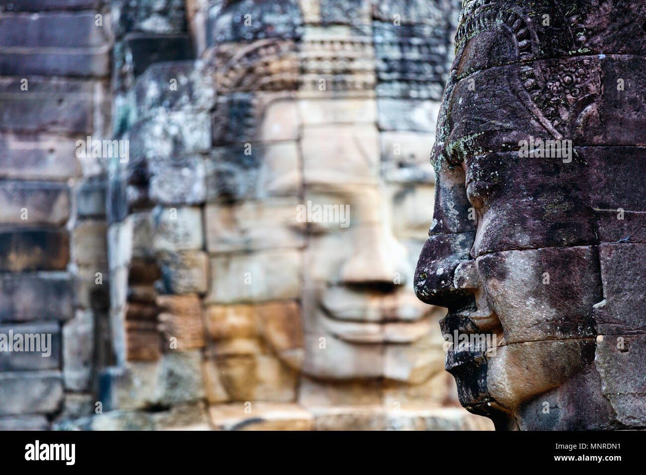 Faces of ancient Bayon temple popular tourist attraction in Angkor Thom,  Siem Reap,  Cambodia. Stock Photo