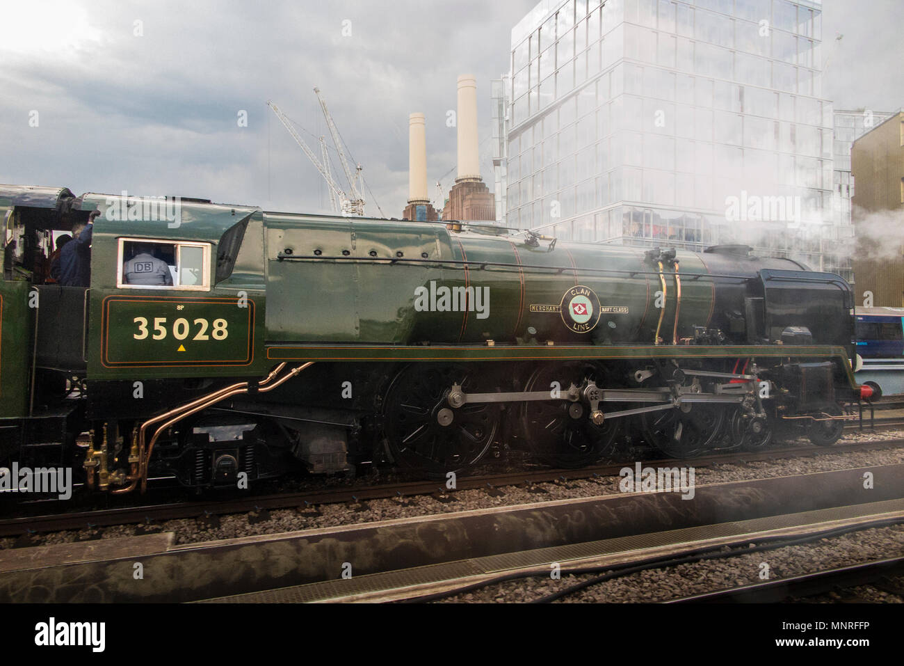 A steam engine locomotive  on it's way past the iconic Battersea Power Station in Central London Stock Photo