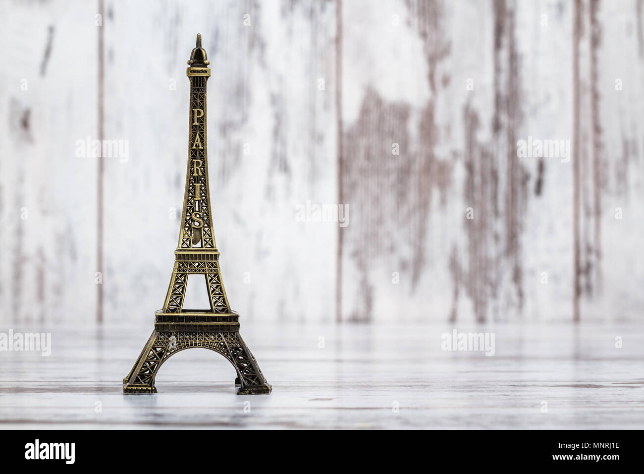 Statue model of eiffel tower on white wooden background Stock Photo - Alamy