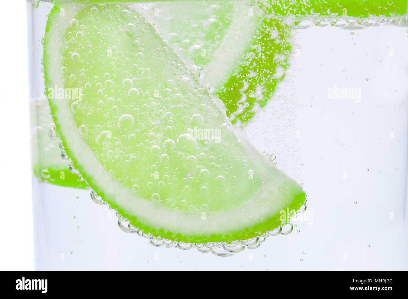 Pieces of fresh juicy lime sink into clear water Stock Photo Alamy